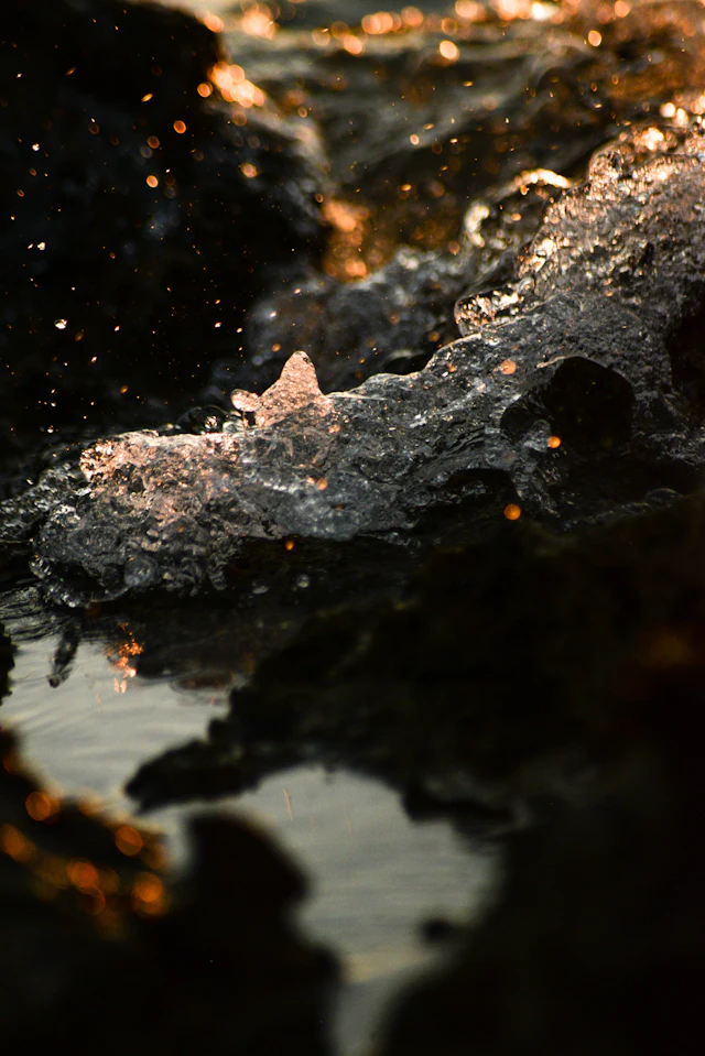 Water splash on black rock — photograph by Ibrahim Ifaaz, Maldives