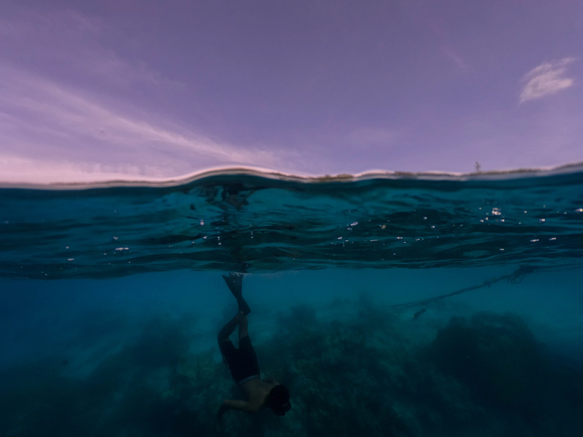 A man swimming in open water off the Maldives, photograph by Ibrahim Ifaaz